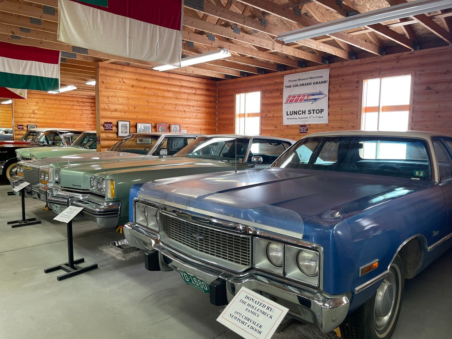 A row of old cars are lined up in a garage.