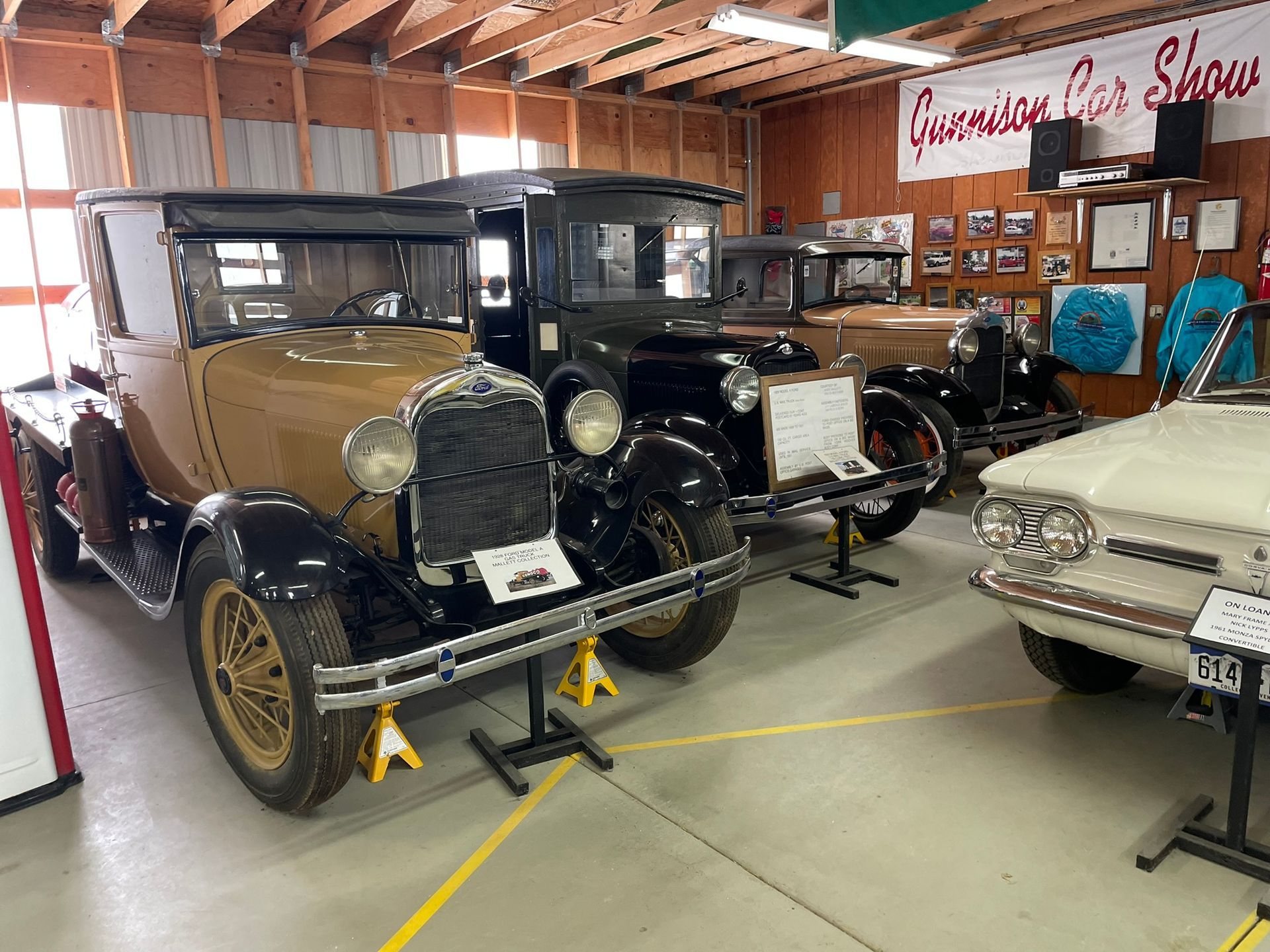A row of old cars are lined up in a garage.