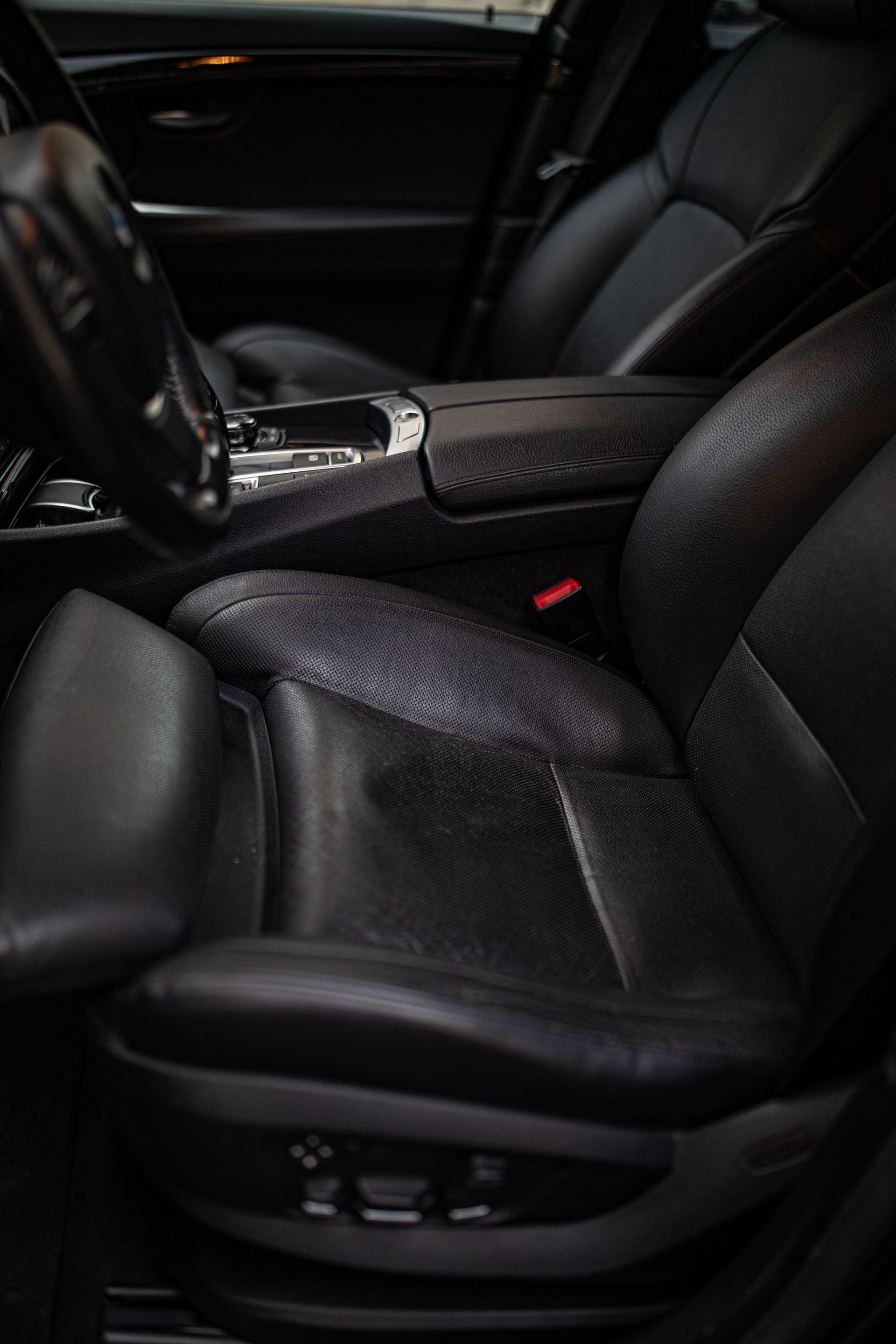 Black leather car seat and center console in a dark vehicle interior