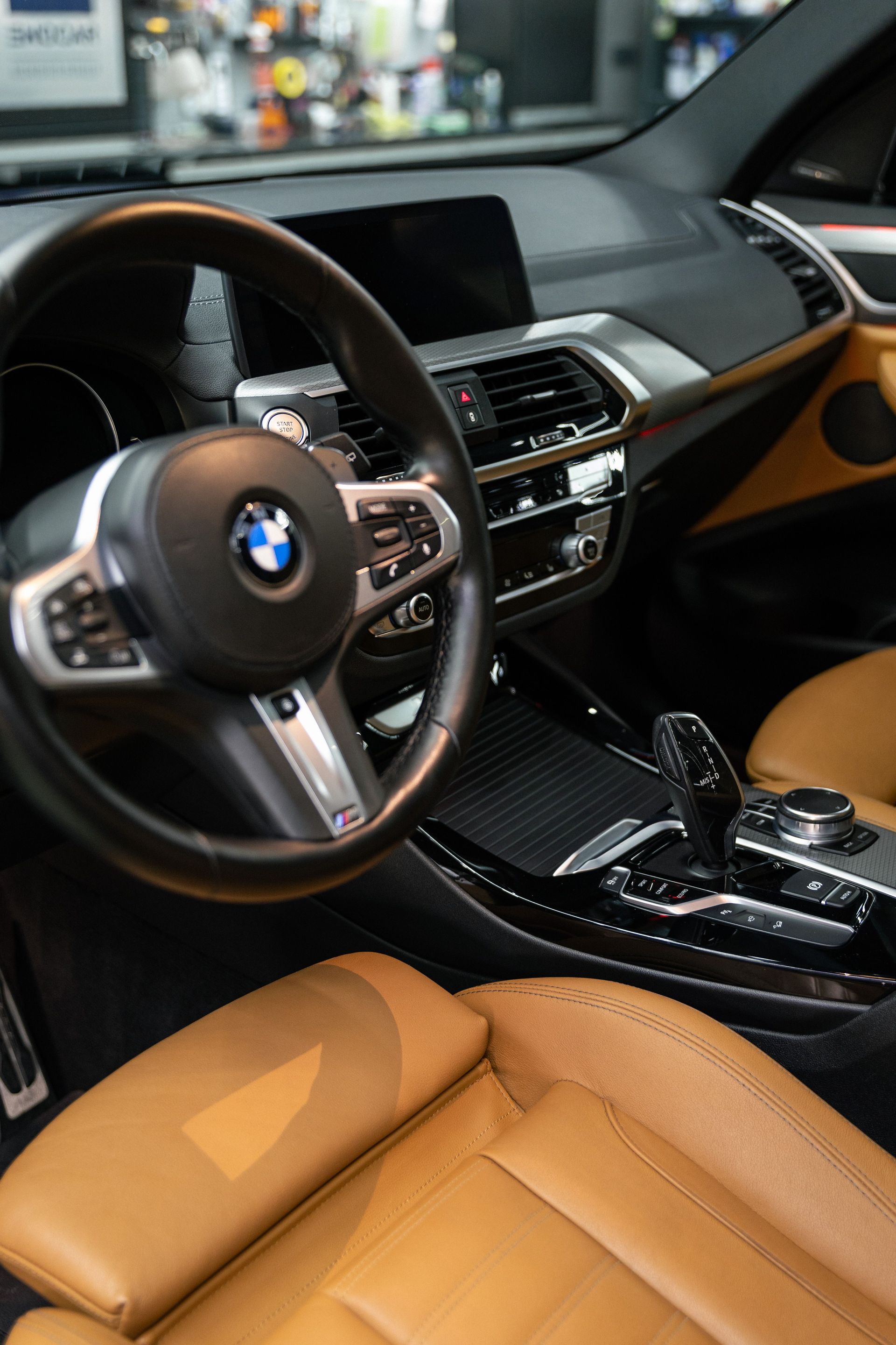 Luxury BMW car interior with tan leather seats and black dashboard details