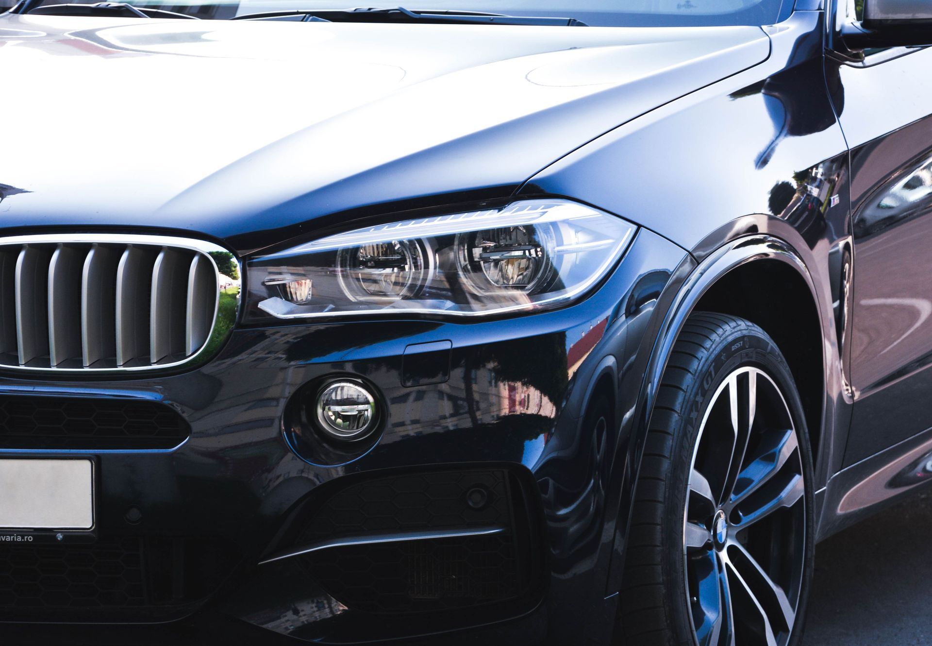 Front view of a black BMW SUV with chrome grille and headlights in an outdoor setting