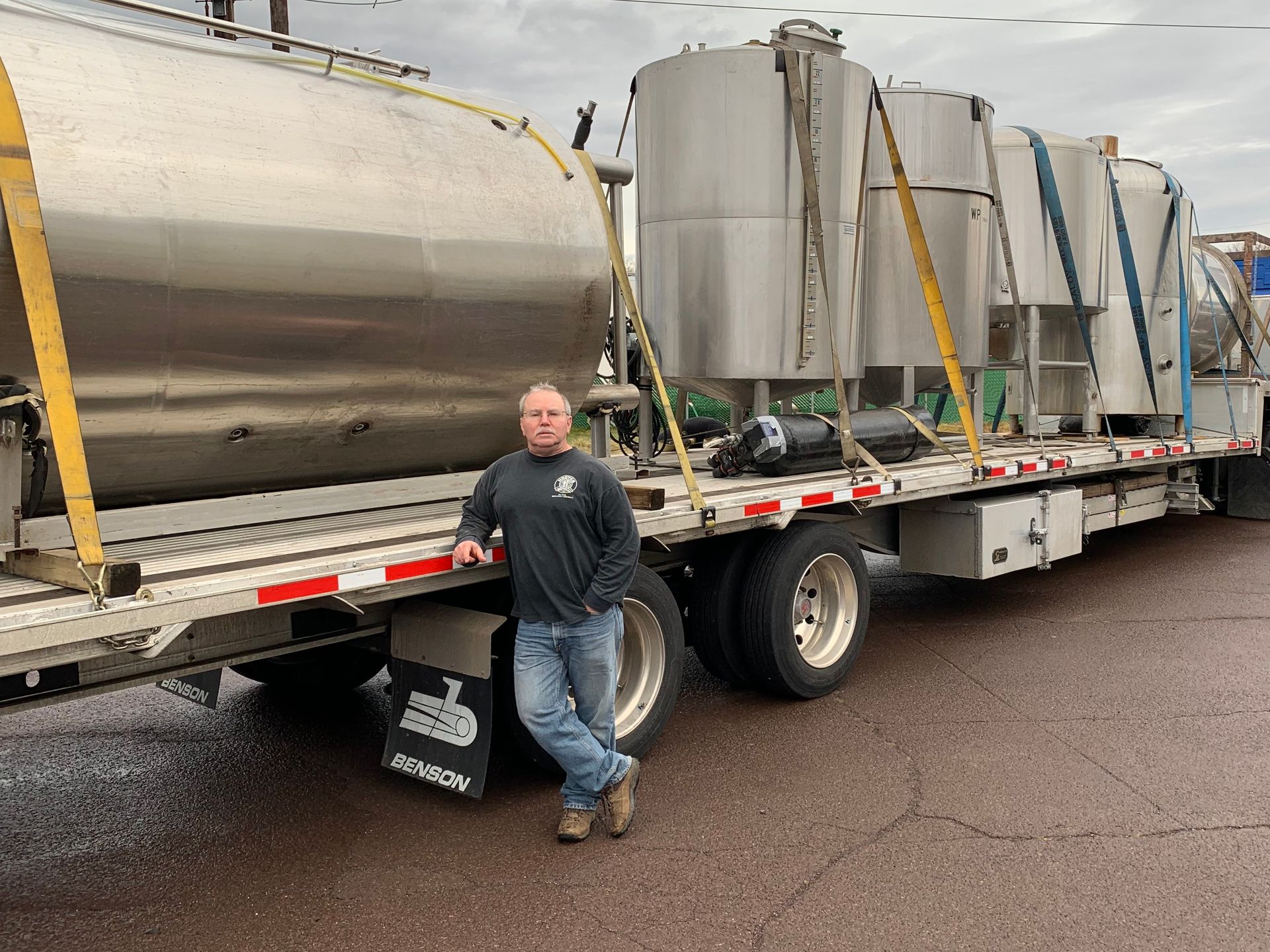A.J. Zanyk next to a trailer carrying brewing vessels