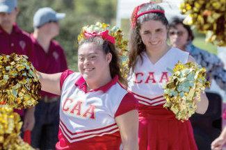 two cheerleaders are holding pom poms in a parade .