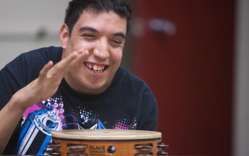 a man in a black shirt is playing a tambourine