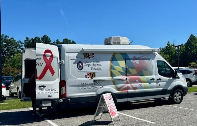 Mobile health clinic van with colorful graphics parked in a lot on a sunny day