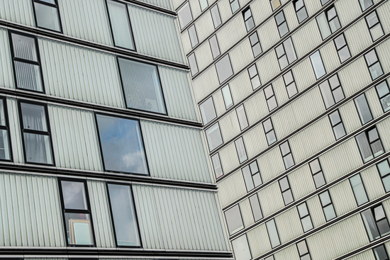 Gevel van een modern gebouw, gefotografeerd met nadruk op ramen en lijnen