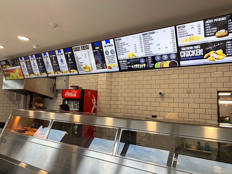 a stainless steel counter in a restaurant with a coca cola refrigerator .