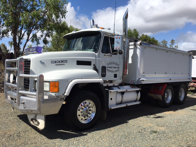 White Mack dump truck parked outdoors under a blue sky — Chewies Tipper Hire & Haulage in Gracemere, QLD