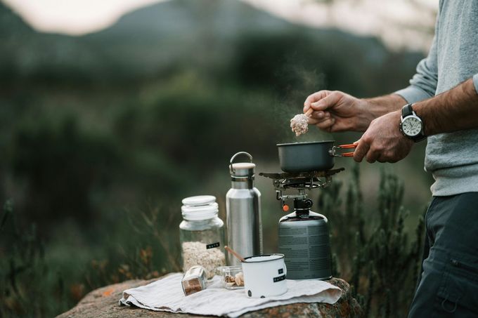 uomo che cucina in campeggio