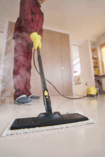 A person is cleaning the floor with a mop and vacuum cleaner.
