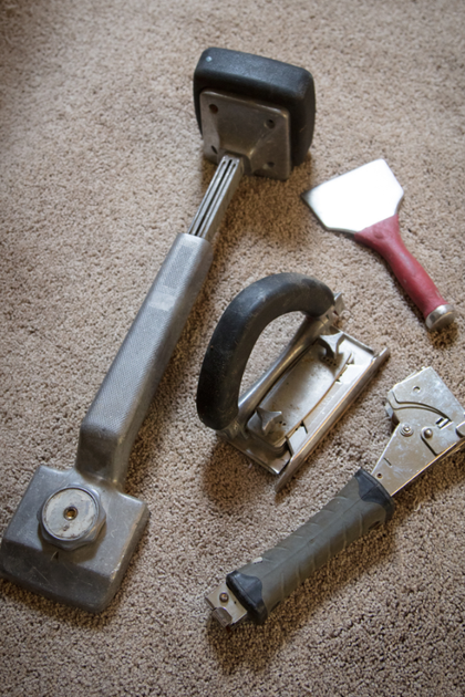 A man is kneeling on the floor using a vacuum cleaner.