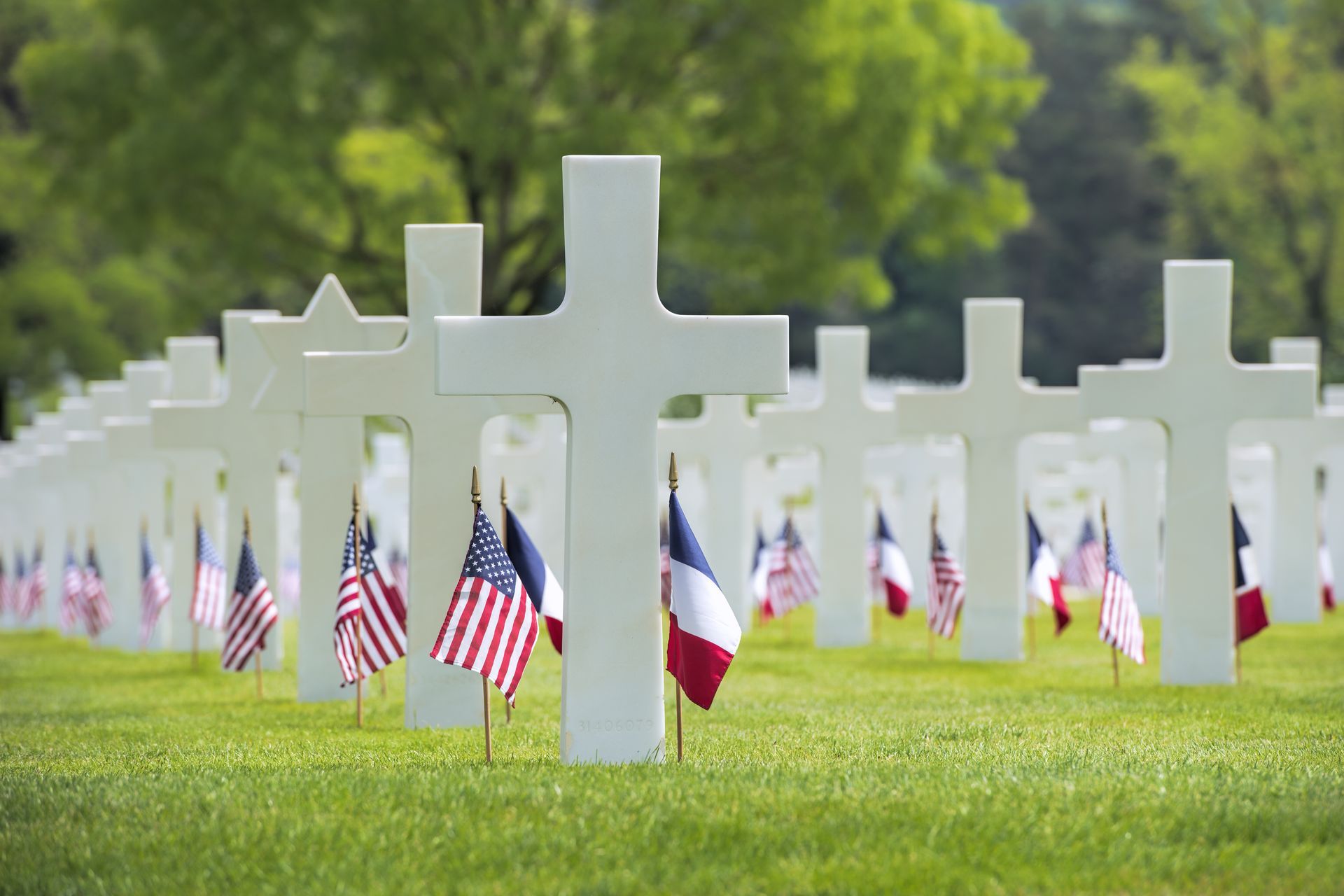 White crosses and flags in a cemetery on a sunny day. White crosses and flags in a cemetery on a sunny day.