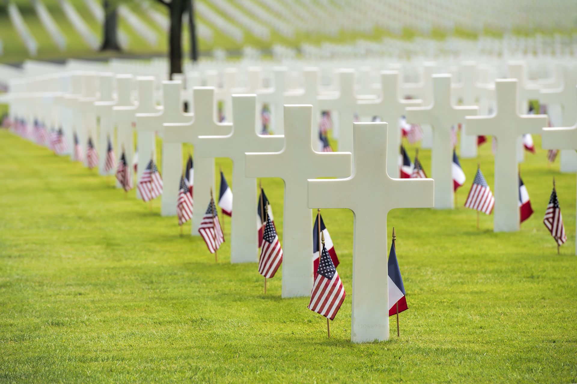 Memorial monuments with white crosses and American flags honoring fallen soldiers in a cemetery. Memorial monuments with white crosses and American flags honoring fallen soldiers in a cemetery.