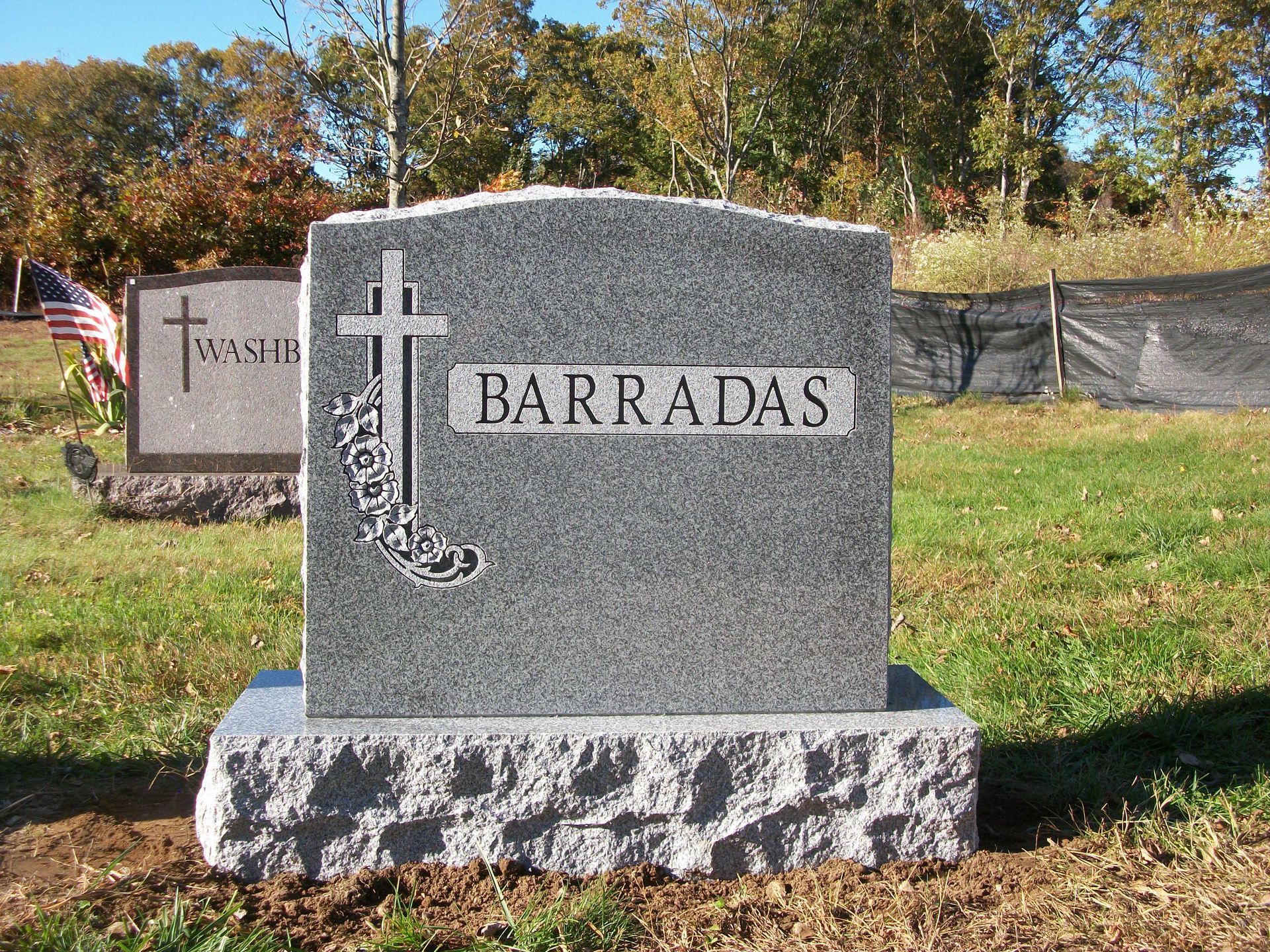 A gray granite headstone inscribed with 