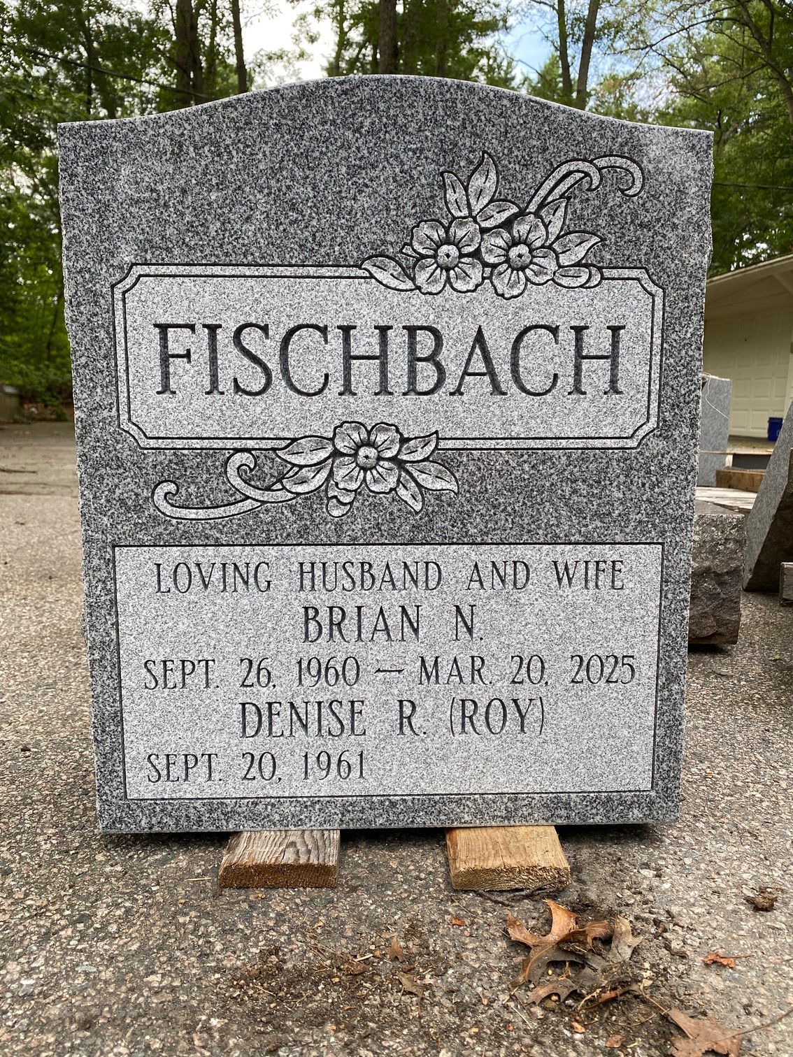 A grey granite headstone engraved with 