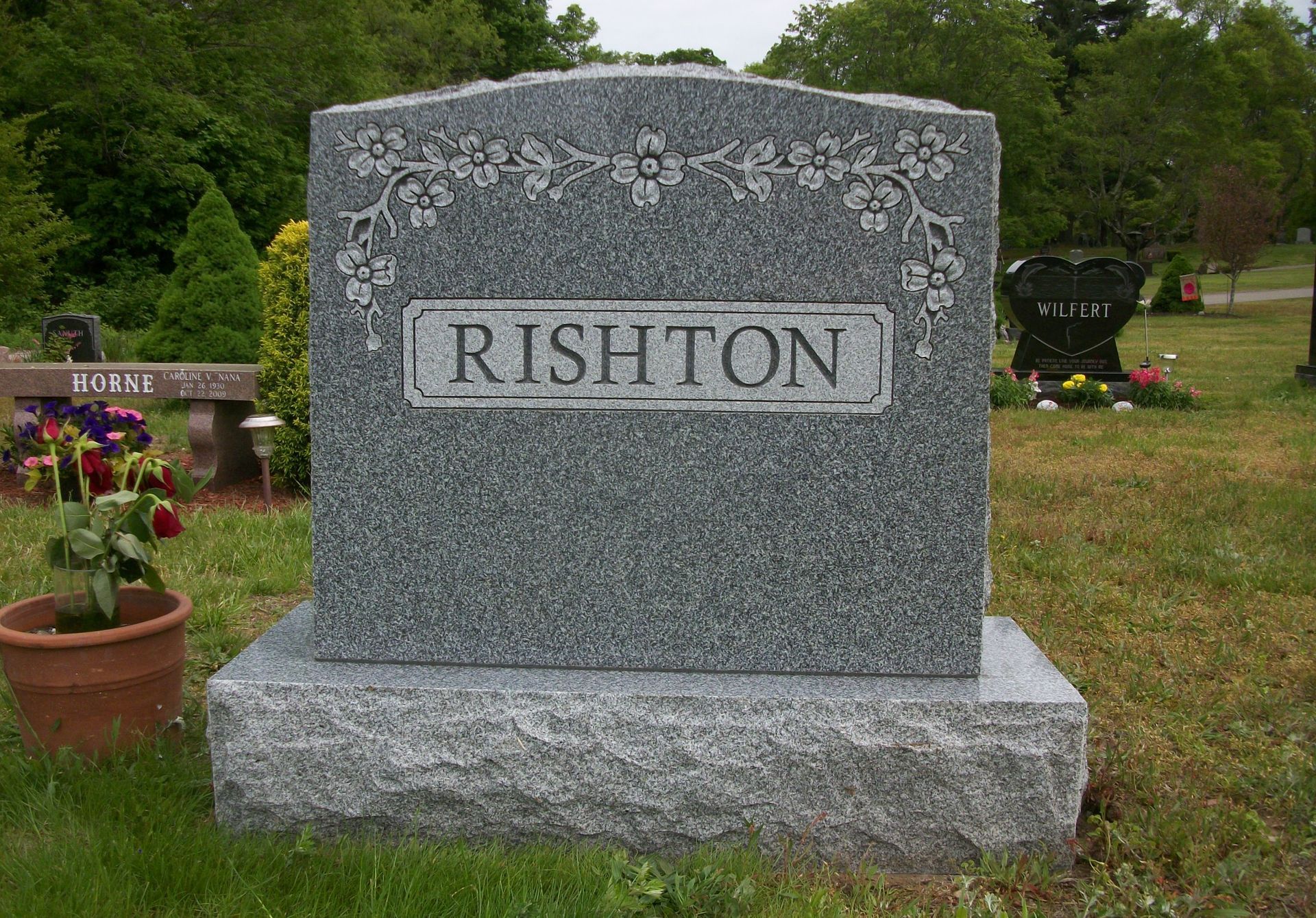 A grey granite headstone engraved with 