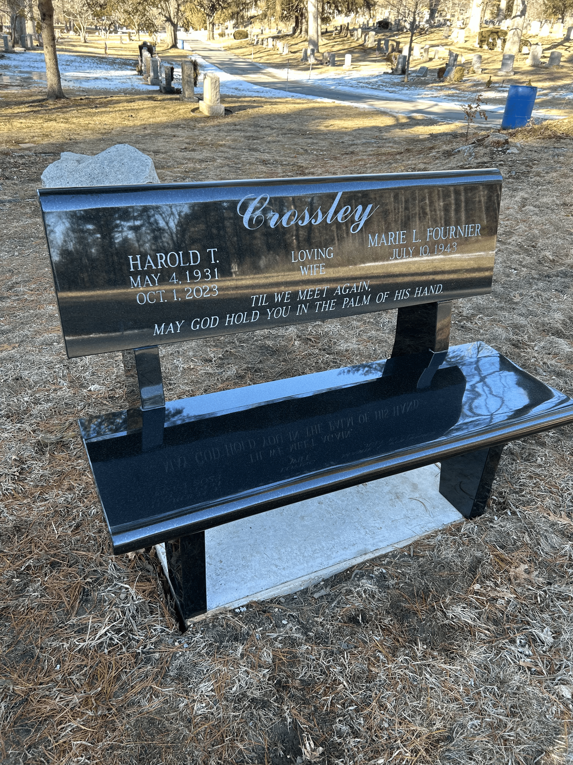 A black granite memorial bench engraved with the name 