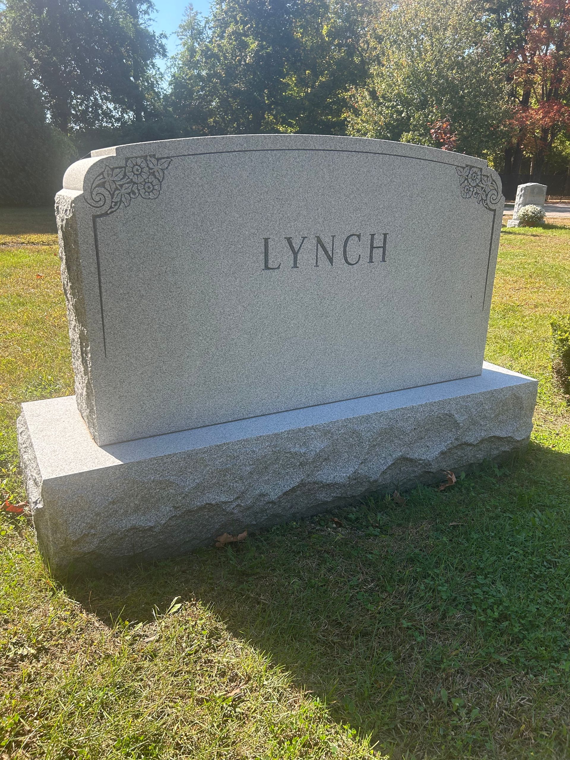 A light gray granite headstone inscribed with the name 