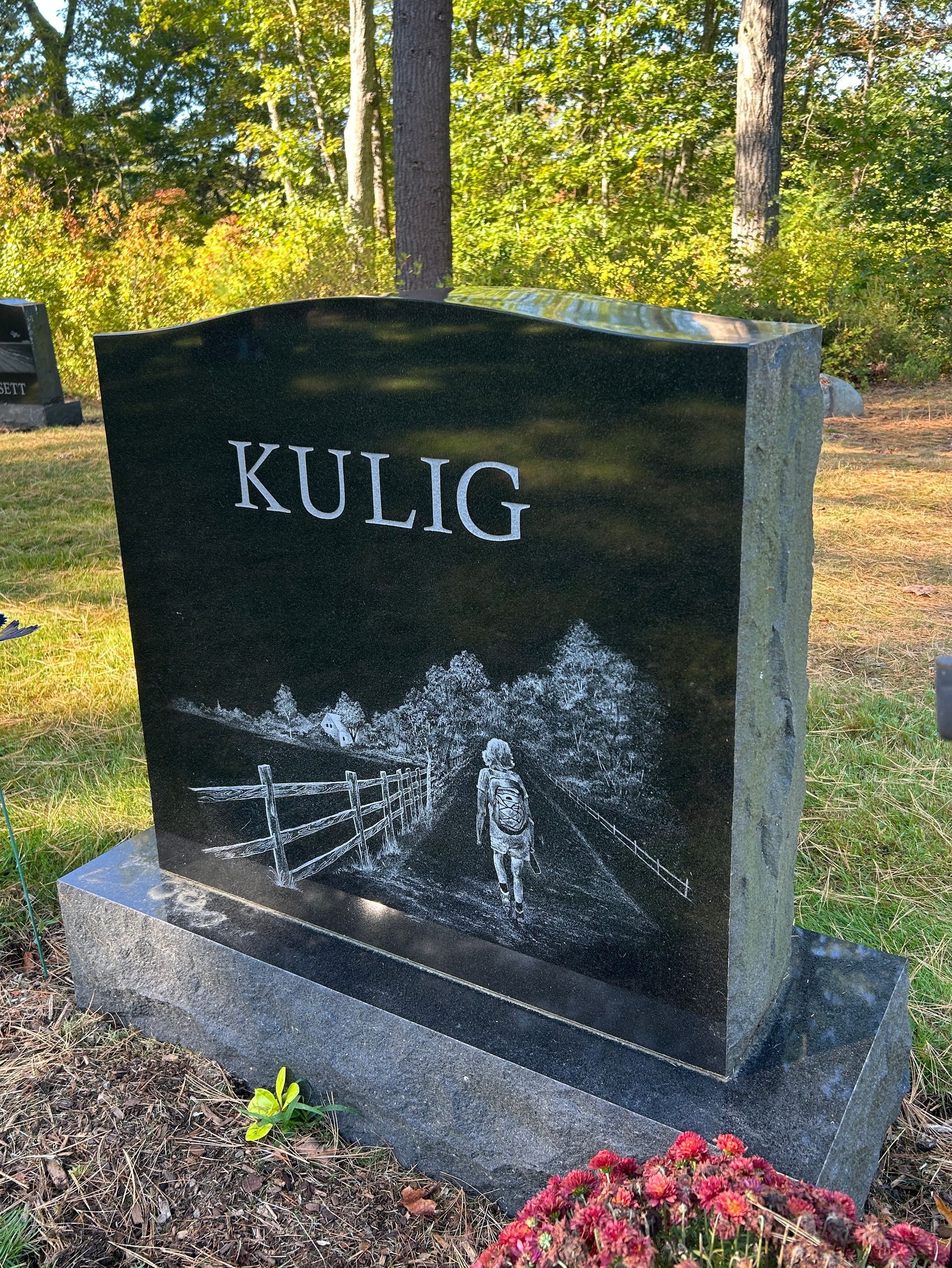 A black granite headstone with the name 