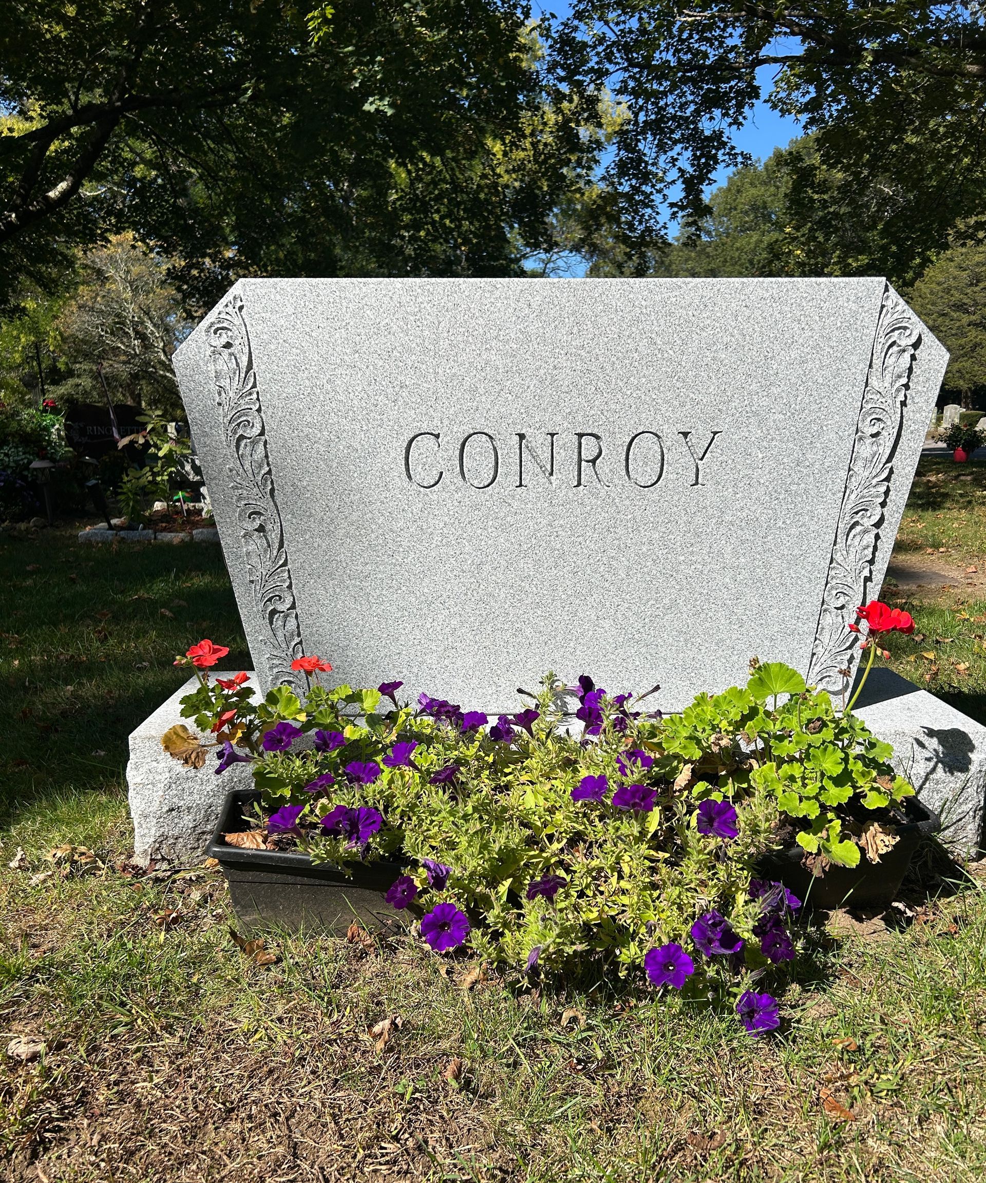 A gray granite headstone inscribed with the name 