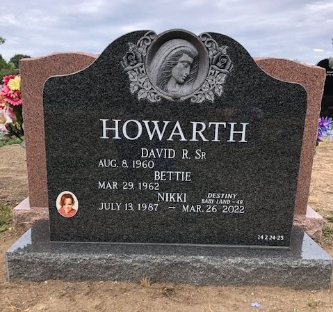 A black granite Howarth family headstone with engraved names and dates, featuring a circular relief of a person's profile.