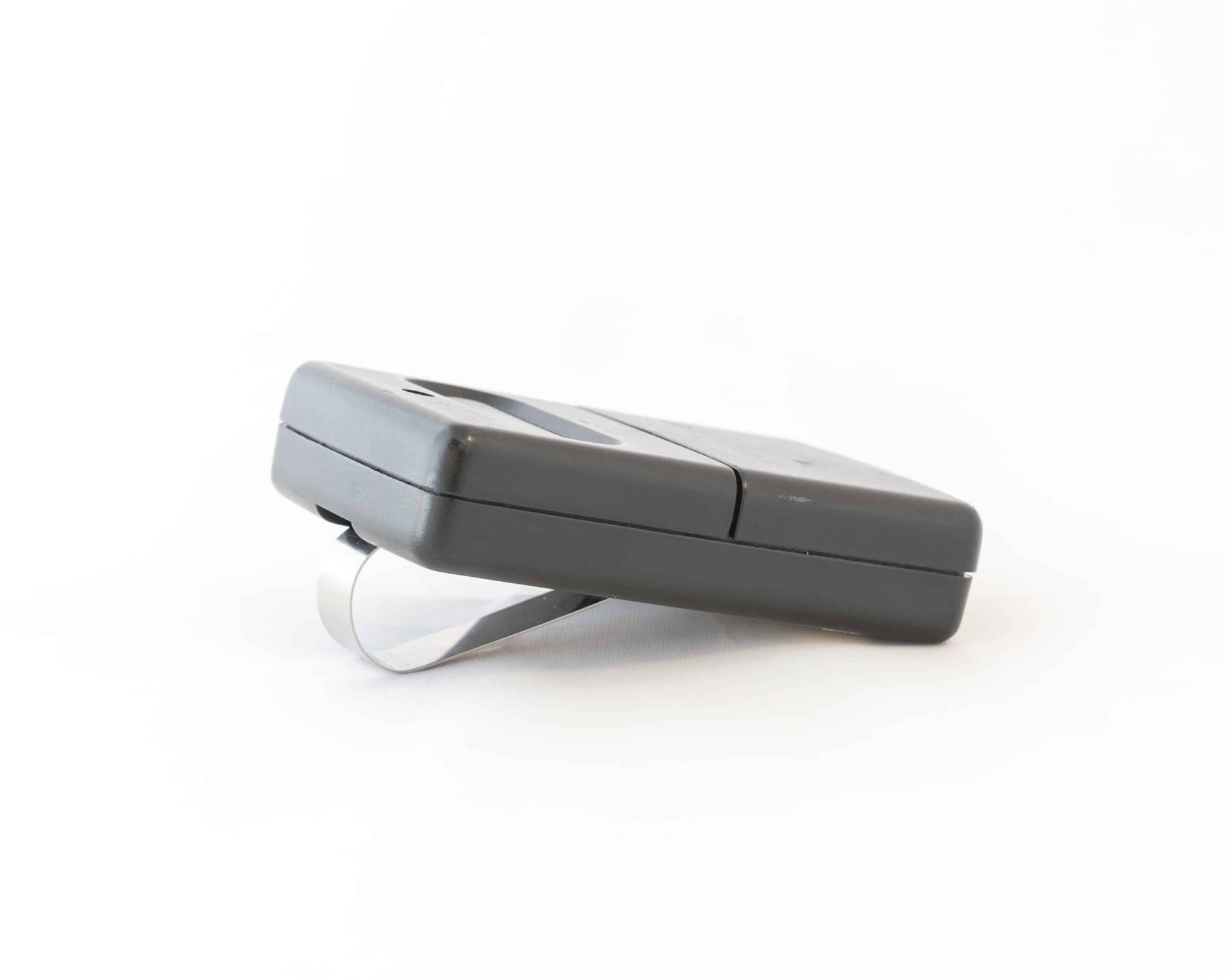 A picture of a garage door opener remote against a white background