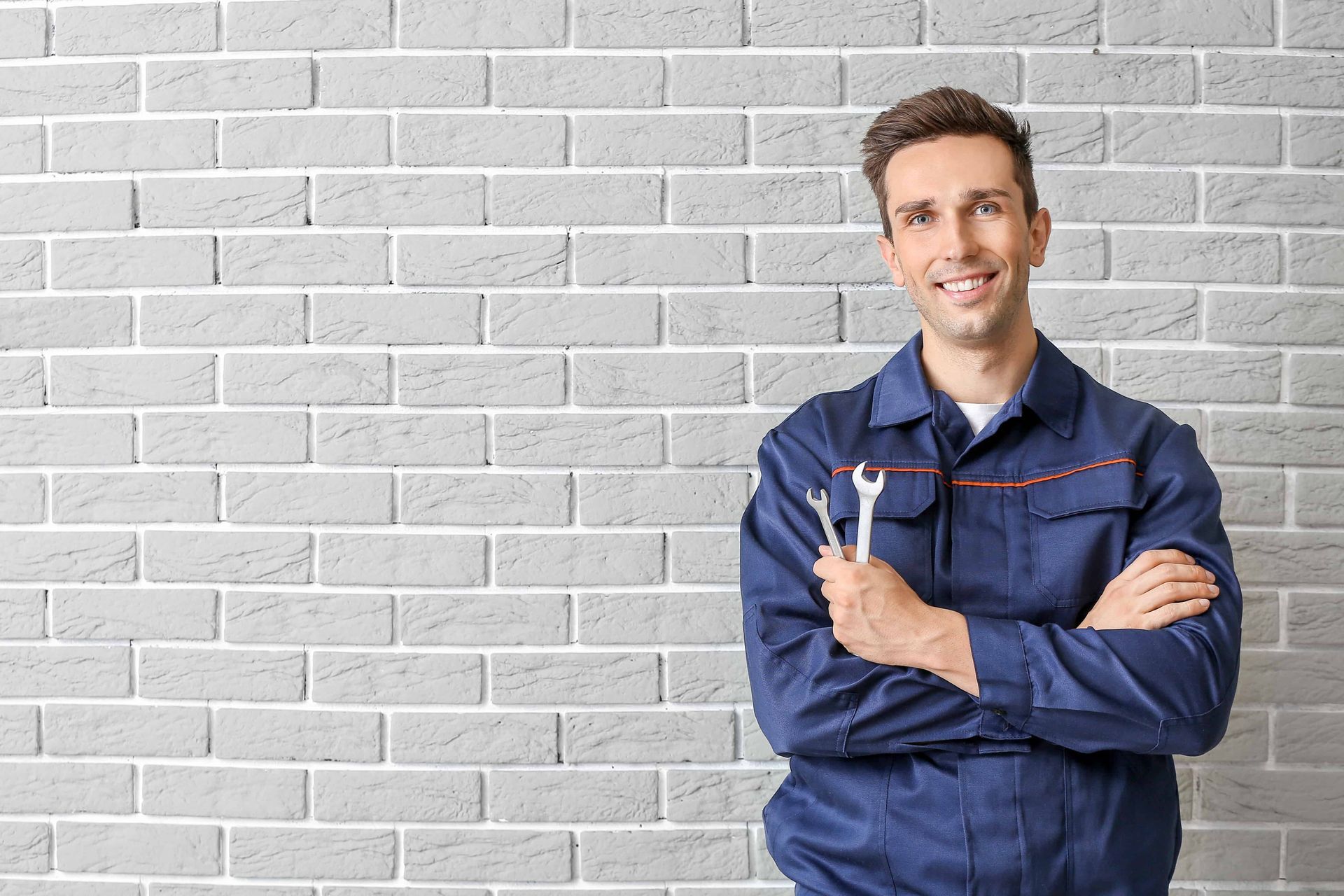 A skilled garage technician holding some tools