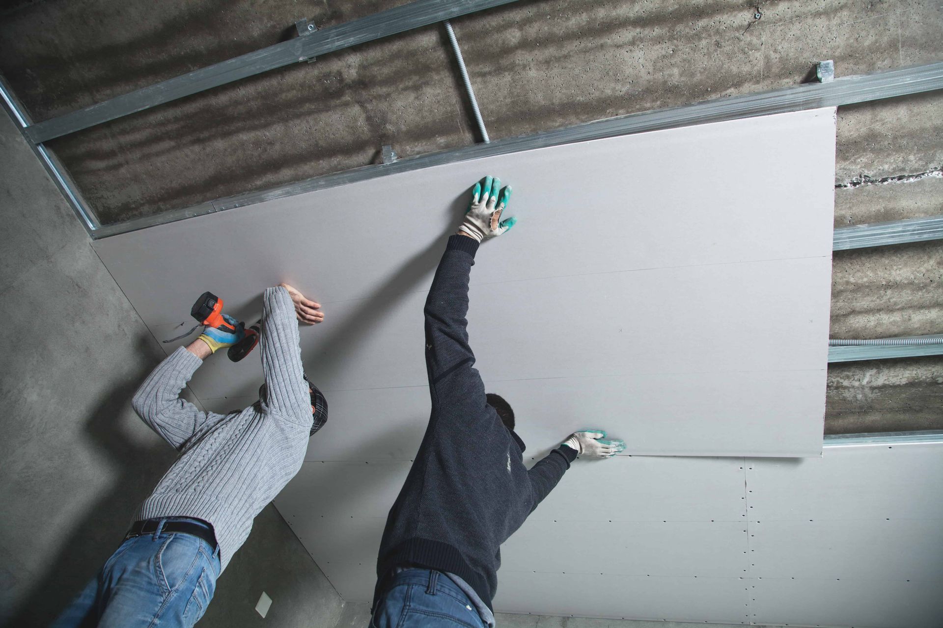 Men installing sheets of insulation in a garage