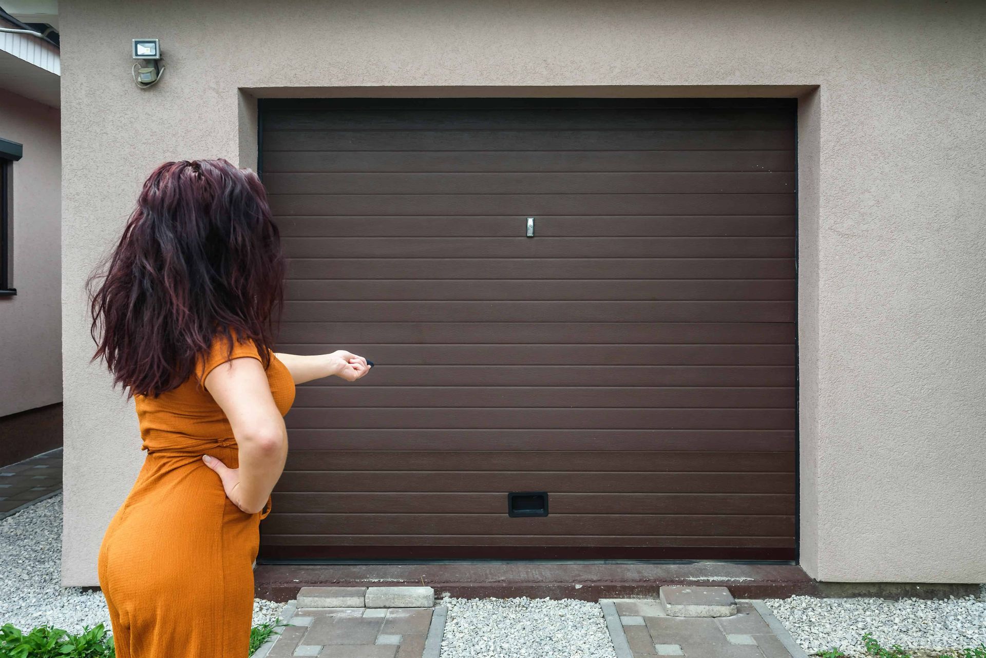 Woman opening a garage door with a remote