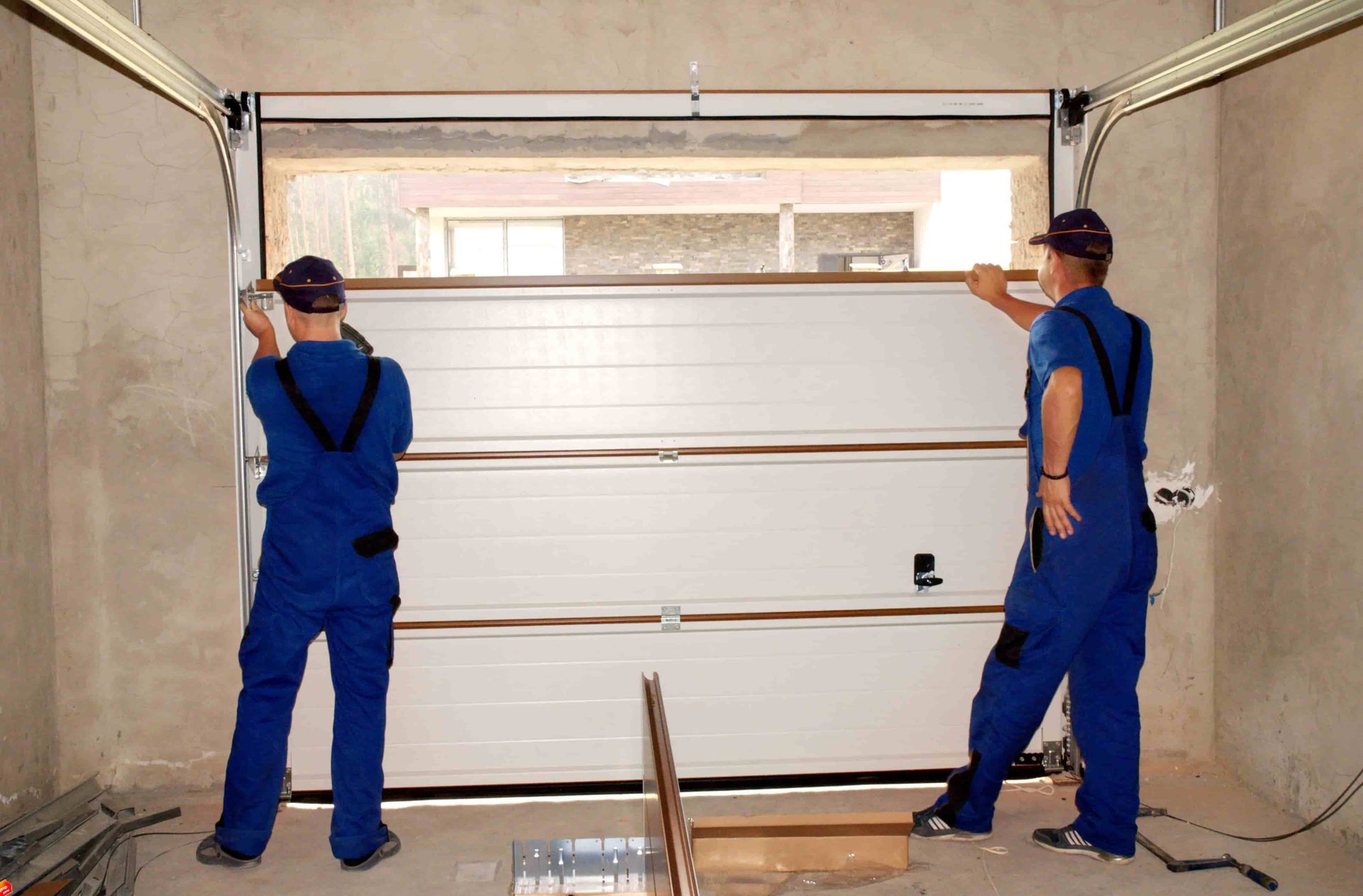 Workers fixing a garage door panel