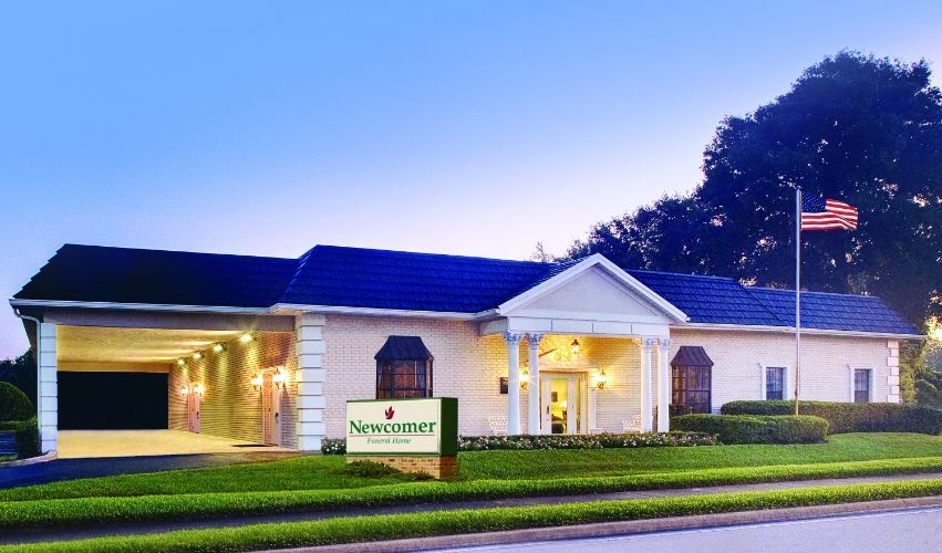 A funeral home with a sign in front of it