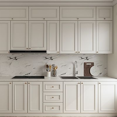 A kitchen with white cabinets , a sink , a stove , and a cutting board.