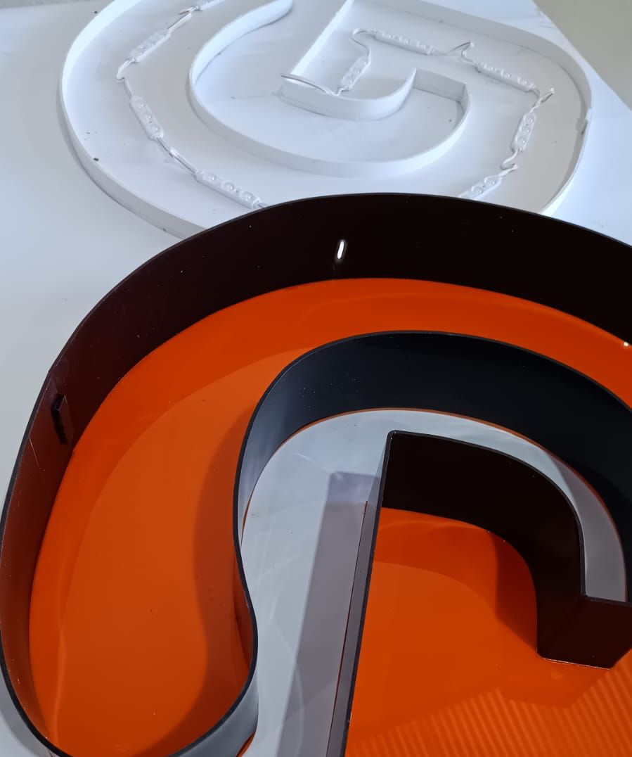 Dois objetos circulares de plástico, um branco e outro laranja e preto, empilhados sobre uma superfície.