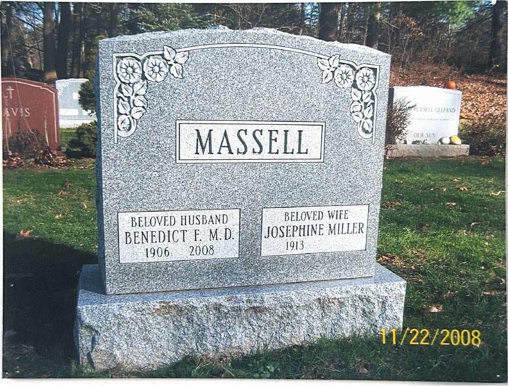 Granite cemetery headstone with the name “MASSELL” and two smaller inscription plaques at the base.