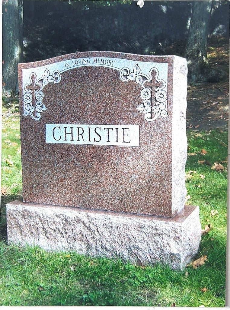Brown granite gravestone engraved “CHRISTIE” in a grassy cemetery area.