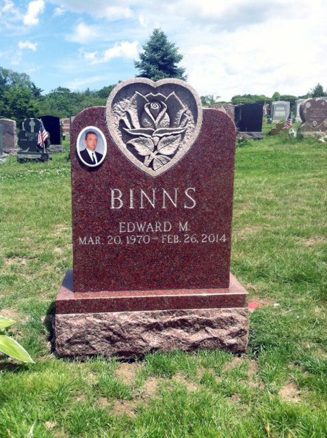 Gravestone for Edward M. Binns in a green cemetery, with a small oval portrait and tree emblem.