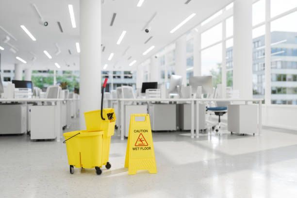 A yellow mop bucket and a caution sign are in an office