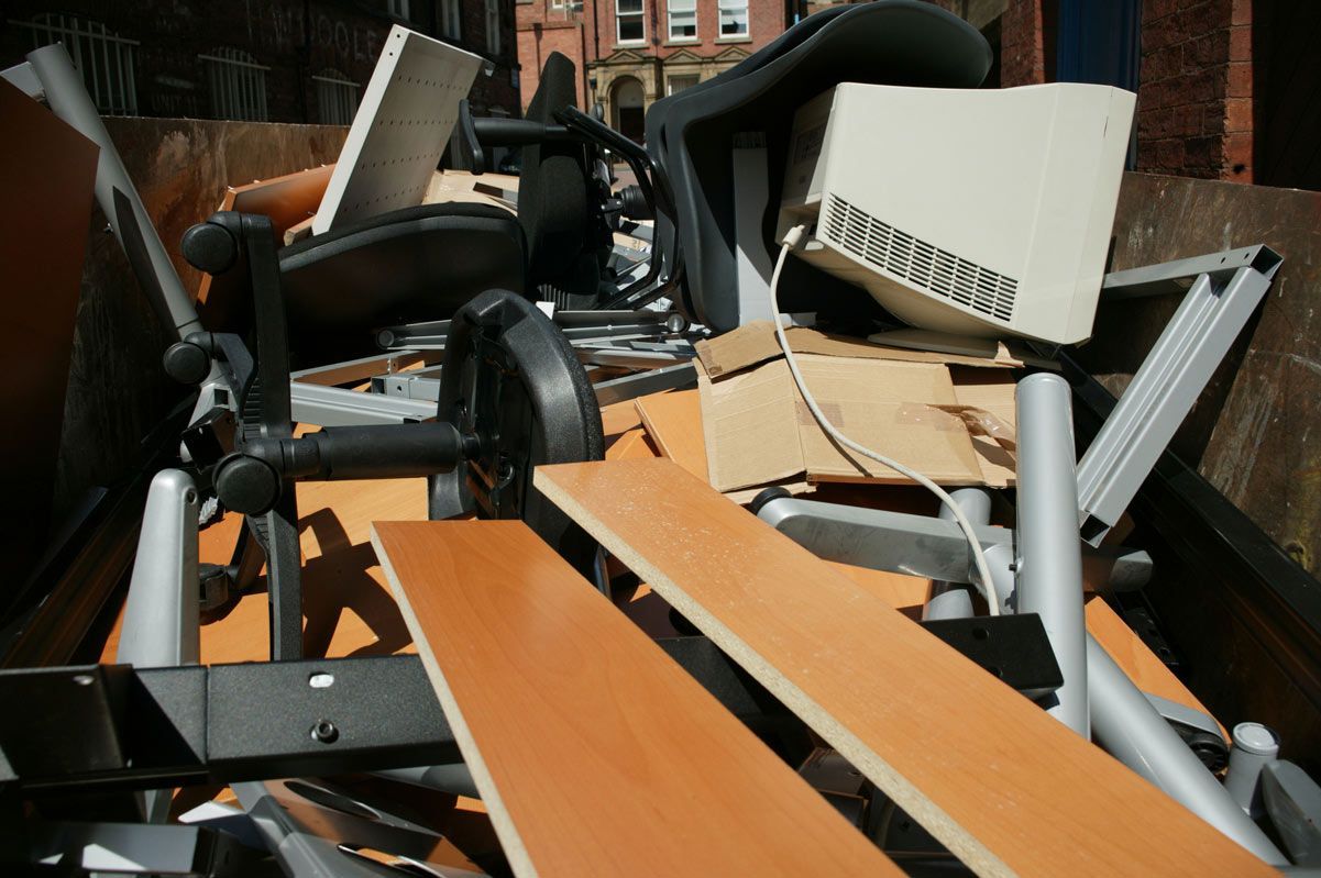 A pile of junk is sitting in a dumpster
