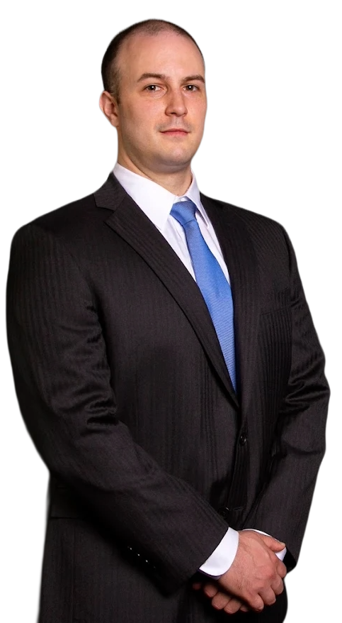 Patrick Welch in dark suit and blue tie, arms crossed, looking at the camera.