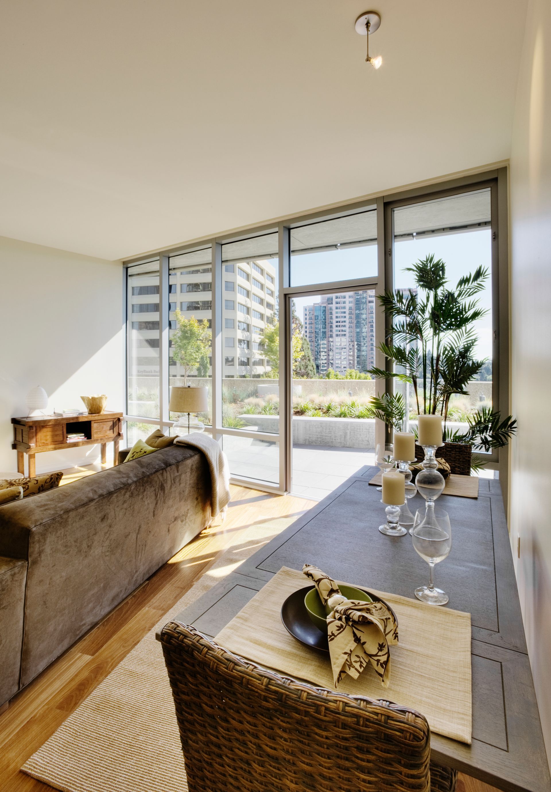 Living room with a dining area, large windows, and an open patio.