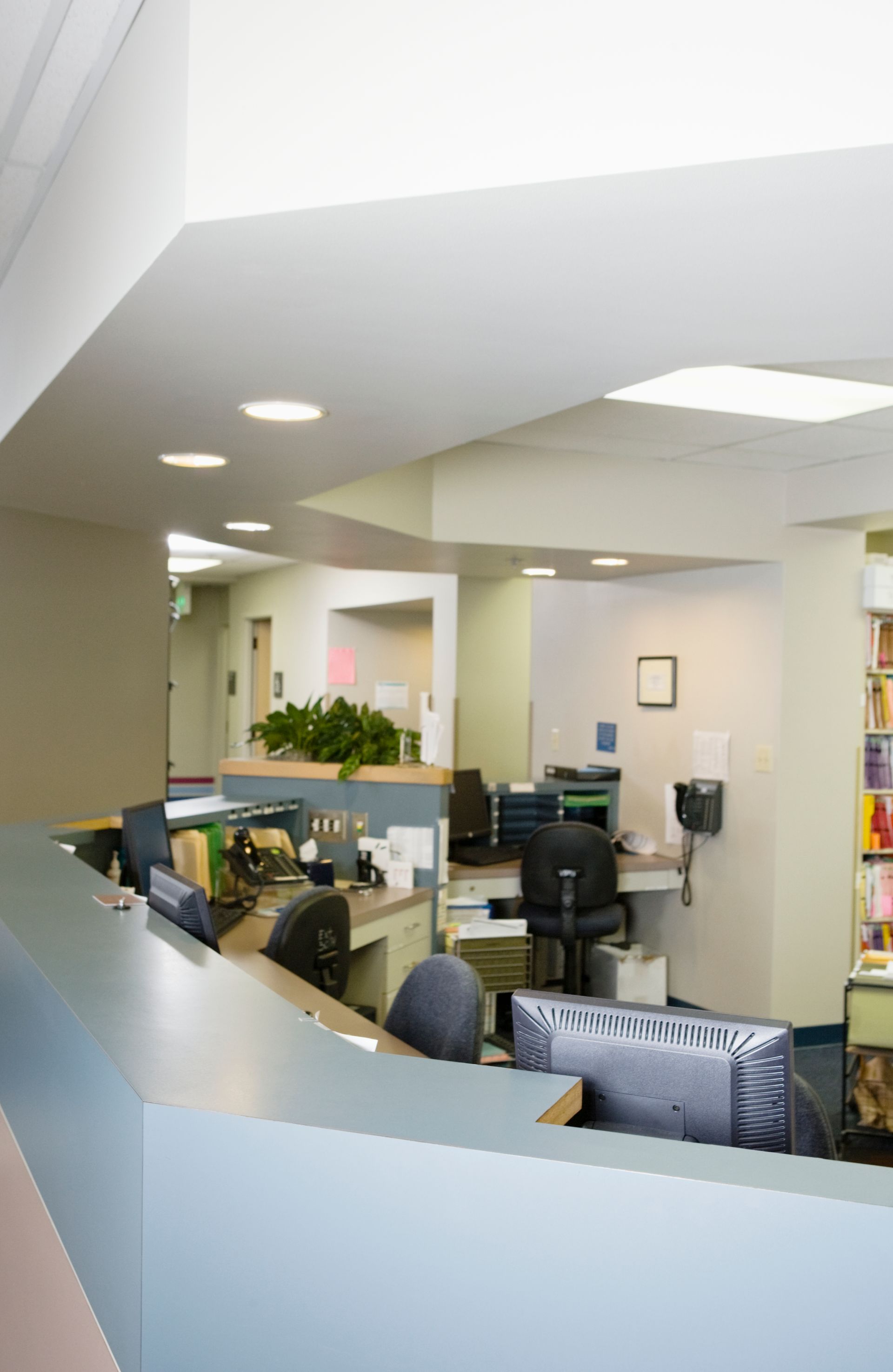 Reception desk in a medical office, featuring computer screens and paperwork.