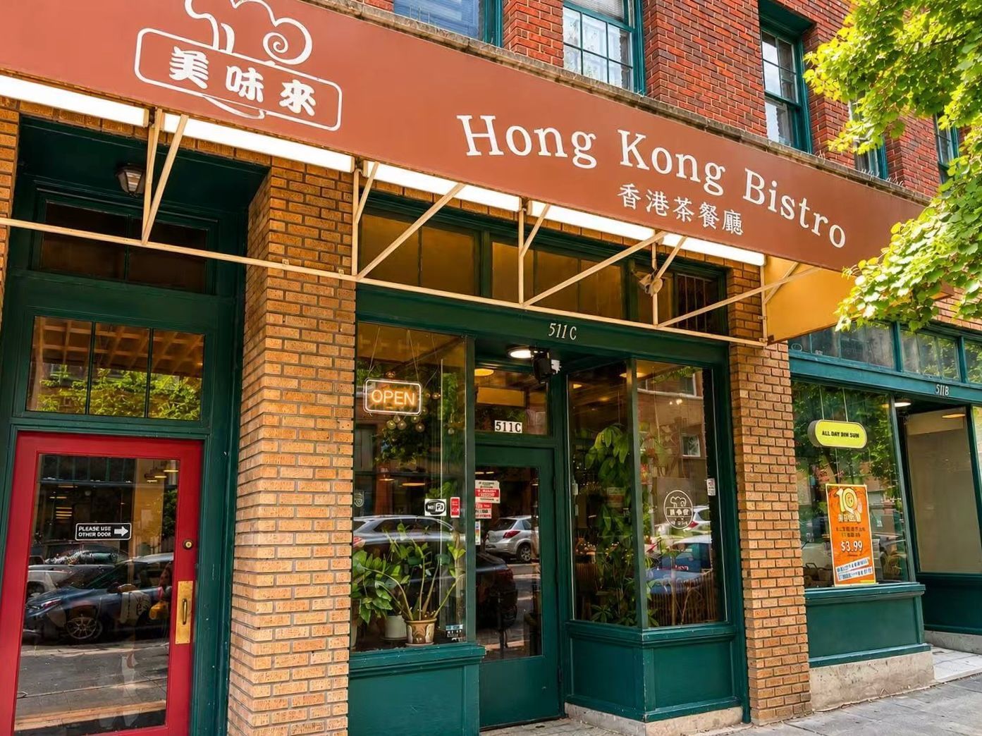 Hong Kong Bistro storefront with red awning, green doors, and brick facade on a sunny street