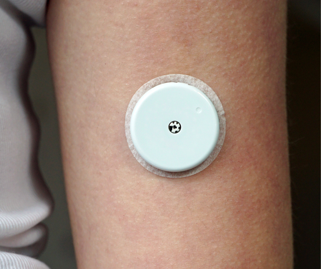 A person 's arm with a small white button on it