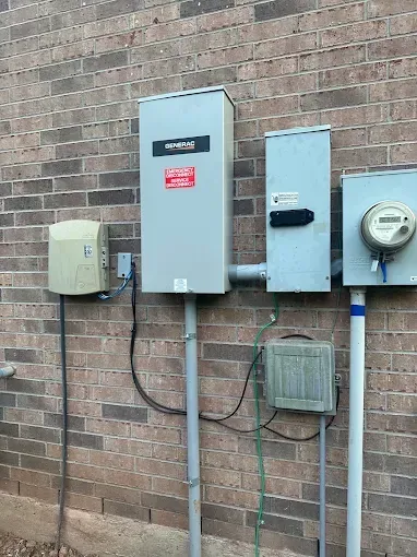 Electrical meters and utility boxes mounted on a brick wall with conduits and cables