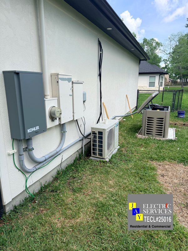 Exterior of a house with utility boxes, HVAC units, and pipes along the wall beside a grassy yard