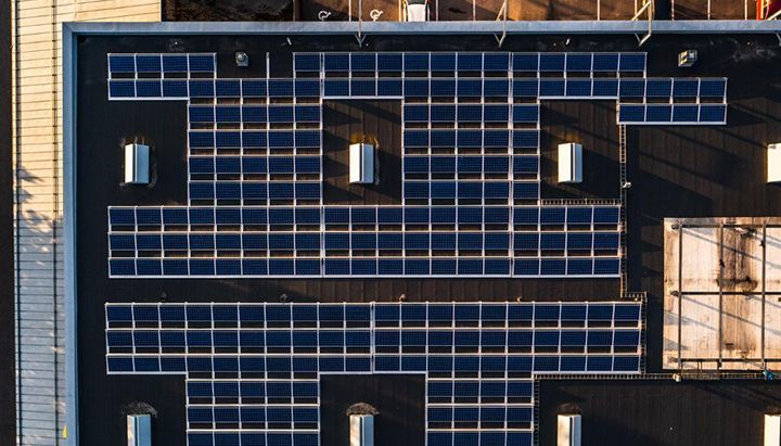 Top view of a commercial roof with solar panels