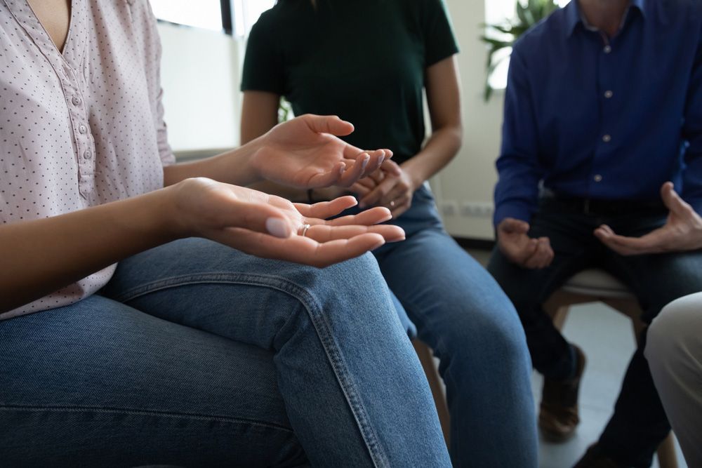 Three People Sitting in a Circle Engage in a Discussion — PoDDSS in Brisbane, QLD