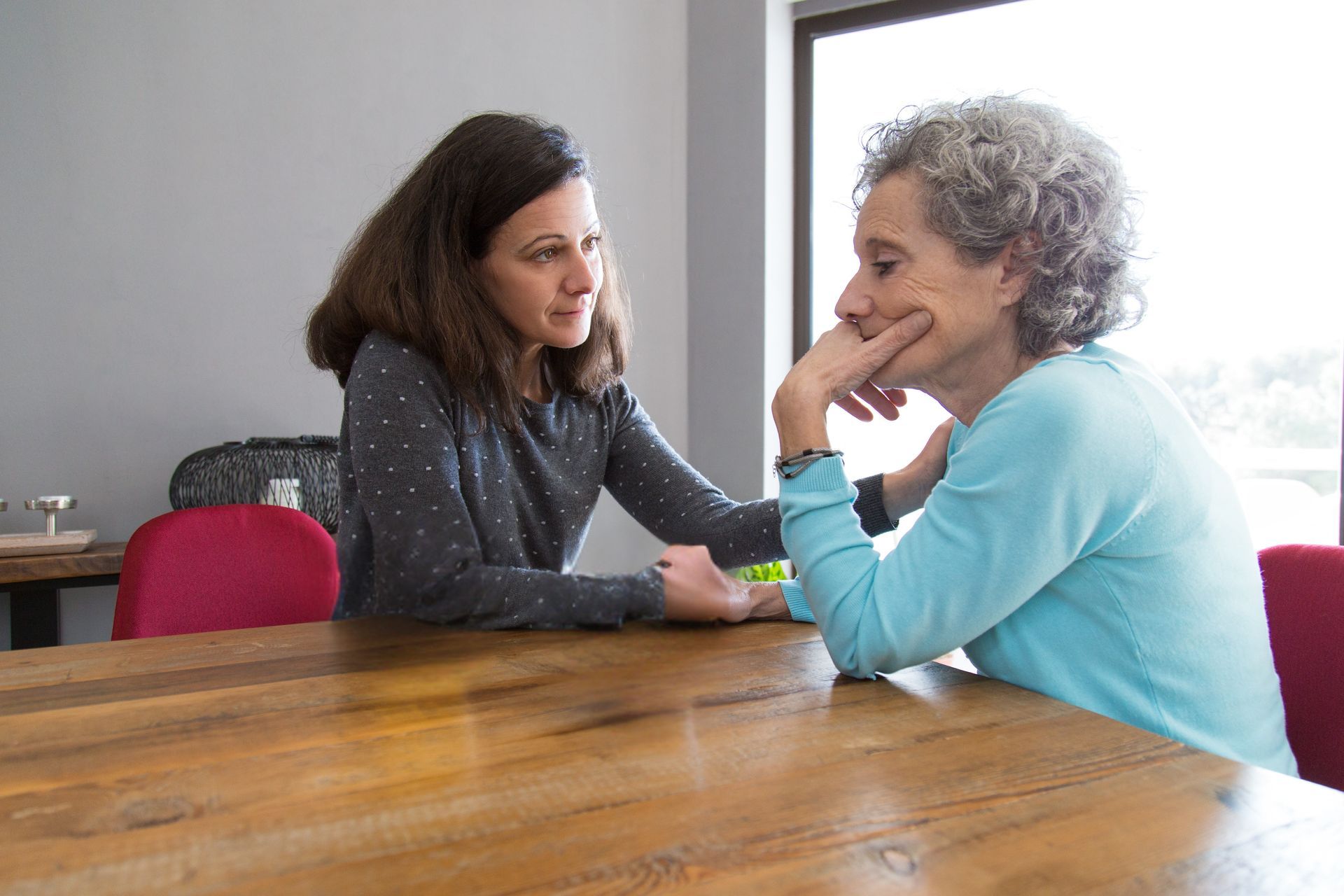 Two women talking across a wooden table in a bright room — PoDDSS in Longreach, QLD