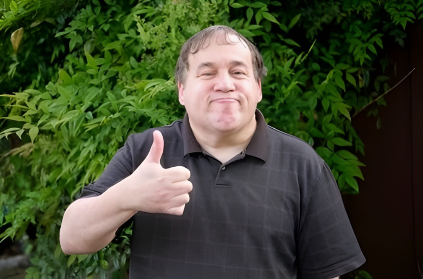A Person in a Black Polo Shirt Giving a Thumbs Up in Front of Green Foliage — PoDDSS in Cairns, QLD