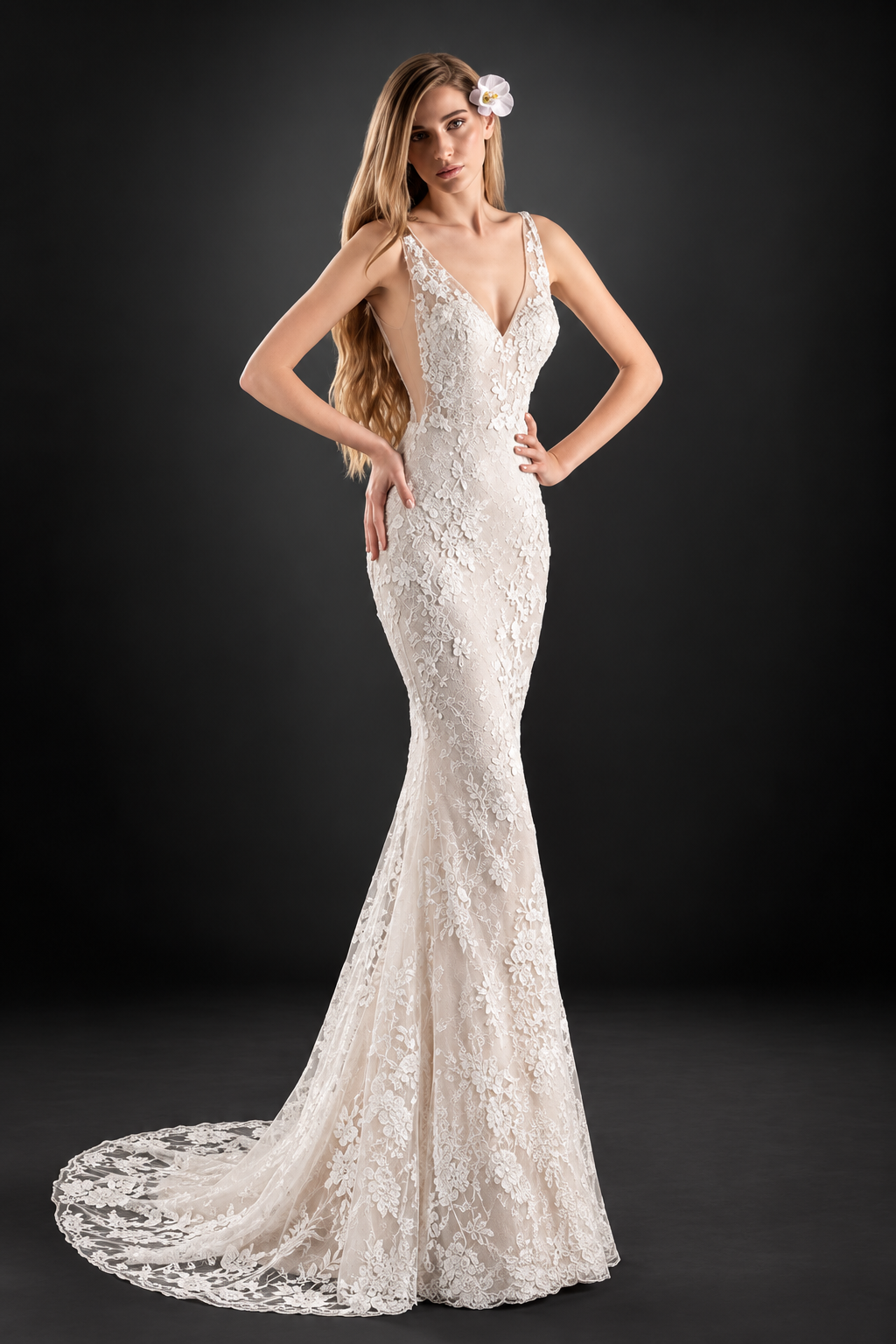 Woman in a white strapless mermaid gown posing indoors by large windows.